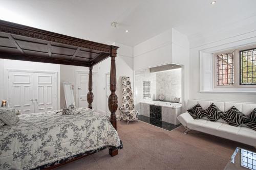 a bedroom with a canopy bed and a bath room at Dalston Hall in Carlisle
