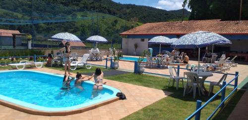 un groupe de personnes jouant dans une piscine dans l'établissement Chacara bora bora, à São Bento do Sapucaí