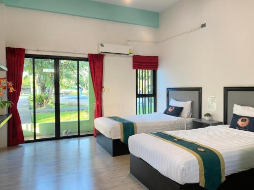 RoomQuest Chonburi Phanat Nikhom tesisinde bir odada yatak veya yataklar