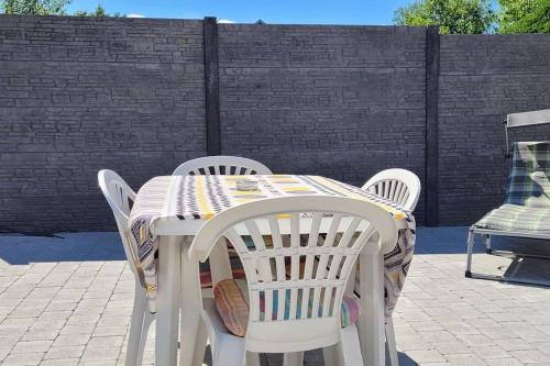 einen weißen Tisch und Stühle auf einer Terrasse in der Unterkunft Il Vialetto, appartement Santa Lucia, au calme, tout confort in Jeumont