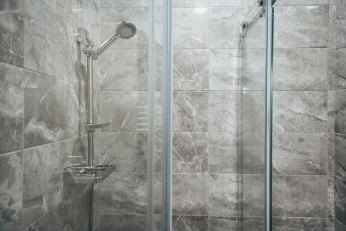 a shower with a glass door in a bathroom at Apart Hotel GH in Tbilisi City