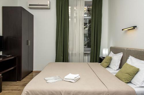 Una habitación de hotel con una cama con toallas. en Apart Hotel GH, en Tiflis