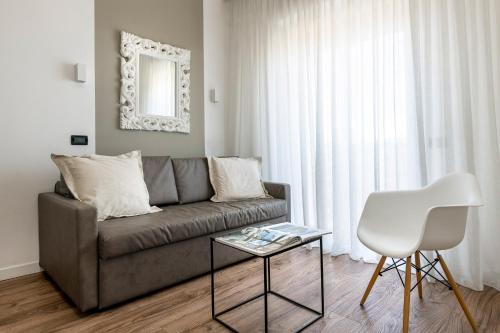 a living room with a couch and a table and a chair at Litoraneo Suite Hotel in Rimini