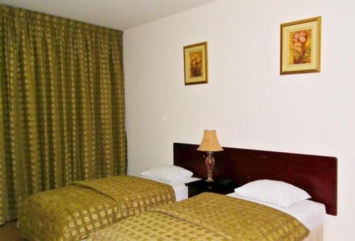a hotel room with two beds in a bedroom at Al Massa Hotel Apartments 1 in Al Ain