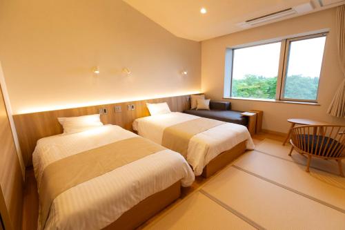 a hotel room with two beds and a window at Kyukamura Chausuyama-Kogen in Toyone