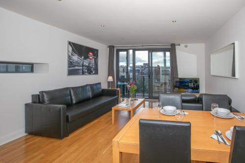 a living room with a table and leather furniture at Parnell Corner Apartments in Dublin