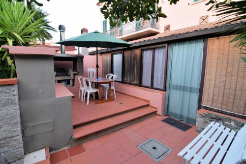 a patio with a table and chairs and an umbrella at Villa Very in Marina di Campo