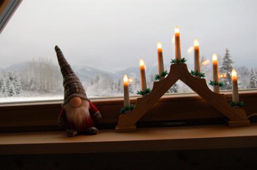 a gnome sitting on a window sill next to candles at Willa Tritri 1 Butikowy dom wakacyjny in Witów