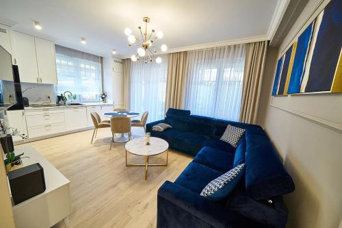 a living room with a blue couch and a table at LAGUNA Apartament 5 "PARYSKI" Willa Leśna in Polanica-Zdrój