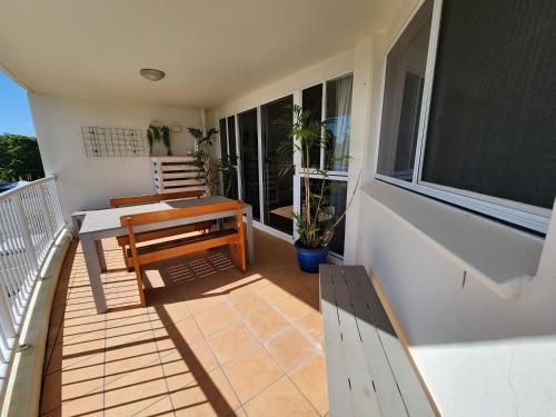 a balcony with a table and chairs on a house at Fairways Golf & Beach Retreat Bribie Island in Woorim