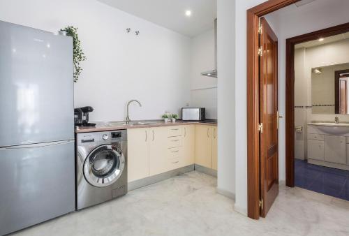 a kitchen with a washing machine and a sink at Acceso Sevilla Piscina Moderno Parking Gratis in Bormujos