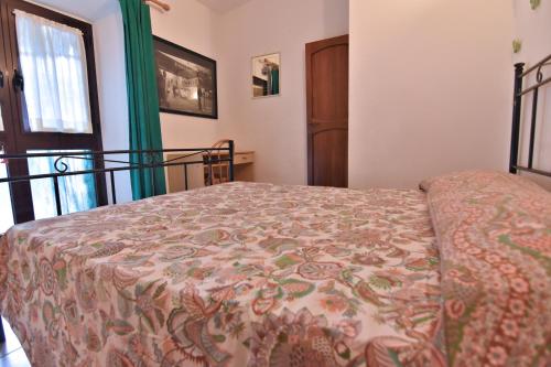 a bedroom with a bed with a flowered bedspread at Villa Very in Marina di Campo