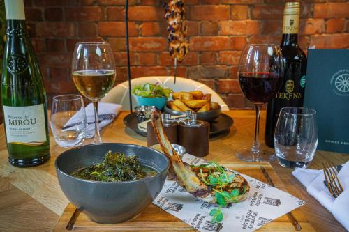 a table with a bowl of food and glasses of wine at The Wynnstay Hotel, Oswestry, Shropshire - The Coaching Inn Group in Oswestry