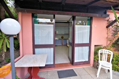 a small pink house with a table and a chair at Villa Very in Marina di Campo