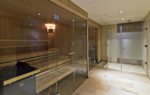 a glass walk in shower in a bathroom at Hotel Waldsee in Lindenberg im Allgäu