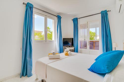 アルクーディアにあるVilla FISHERMAN Alcudiaの白いベッドルーム(青いカーテン、ベッド1台付)