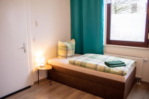a small bedroom with a bed and a window at Exklusives Apartment für 1 bis 3 Personen in Solingen