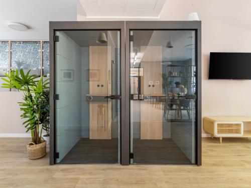 an open glass door in a living room at Limehome Berlin Luise Henriette Str - Digital Access in Berlin