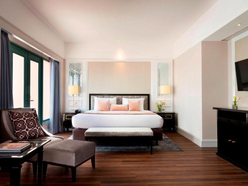um quarto de hotel com uma cama e uma cadeira em Melia Purosani Yogyakarta em Yogyakarta