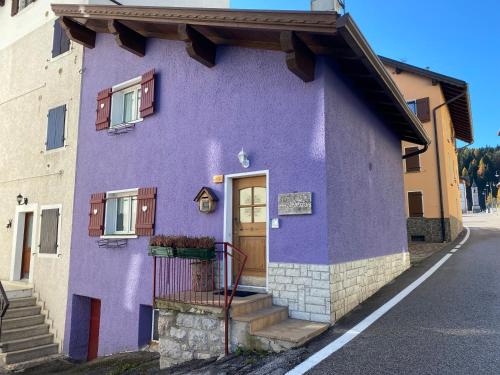 una casa púrpura con una puerta en una calle en Al Sole Mountain Chic, en Folgaria