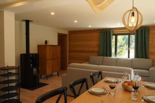 een woonkamer met een tafel en een bank bij L'Etincelle Mountain Lodge in Chamrousse