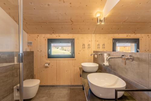 a bathroom with two sinks and a shower at Bergeralm Chalets by ALPS RESORTS in Steinach am Brenner