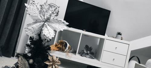 a white entertainment center with a tv and a christmas tree at Divcibare As apartmani in Divčibare
