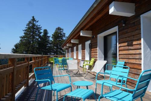 a row of chairs and tables on a deck at L'Etincelle Mountain Lodge in Chamrousse