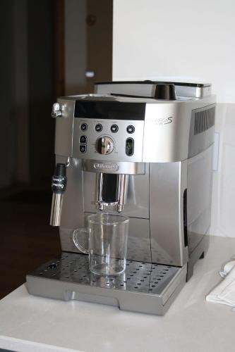 a coffee maker sitting on a counter with a cup at L'Etincelle Mountain Lodge in Chamrousse