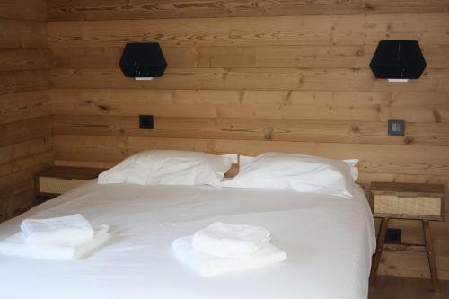 a bedroom with a white bed with two towels on it at L'Etincelle Mountain Lodge in Chamrousse