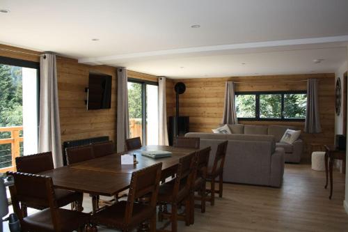 een woonkamer met een tafel en stoelen en een bank bij L'Etincelle Mountain Lodge in Chamrousse
