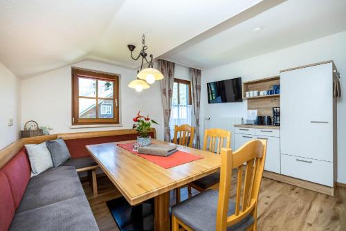 a dining room and kitchen with a wooden table and chairs at Bauernhof Vorderklinglhub in Flachau