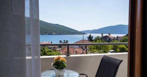 einen Tisch mit einer Blumenvase auf dem Balkon in der Unterkunft Hotel Olimpija plus in Herceg-Novi