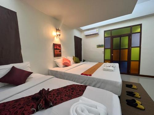 a hotel room with two beds and a window at Rainforest Huahin Village Hotel in Hua Hin