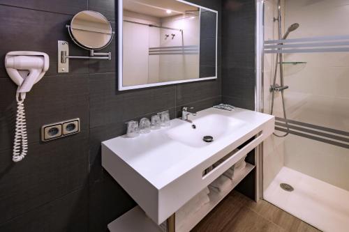 a bathroom with a white sink and a shower at Tropic Park in Malgrat de Mar