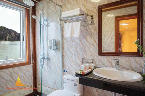 La salle de bains est pourvue d'un lavabo, de toilettes et d'un miroir. dans l'établissement Sunlight Cruise, à Hạ Long