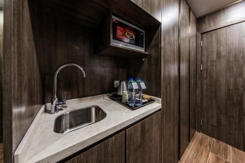 - un comptoir de cuisine avec évier dans la chambre dans l'établissement Lily Hotel Suite Hofuf, à Al Hofuf