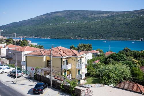 Blick auf ein Haus mit einem See im Hintergrund in der Unterkunft Hotel Olimpija plus in Herceg-Novi