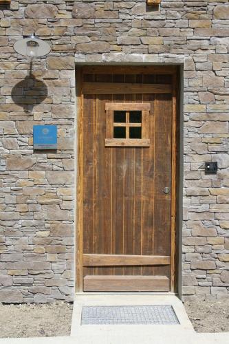a wooden door on a stone building with a sign at L'Etincelle Mountain Lodge in Chamrousse