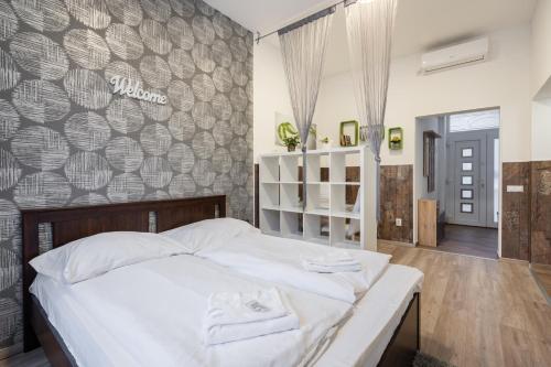 ブダペストにあるSilver Moon Apartment in the city centerの白い大型ベッドと壁が備わるベッドルーム1室が備わります。