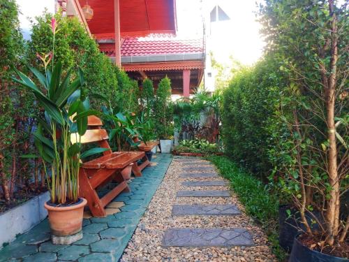 a garden with a bench and plants at Aphilapa Residence in Chiang Mai