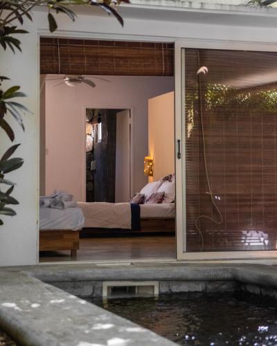 a bedroom with a bed and a pool in a room at Nativ Lodge and Spa in Mahébourg