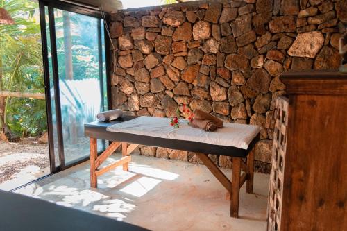 a bench sitting in front of a stone wall at Nativ Lodge and Spa in Mahébourg
