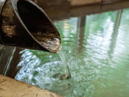 a person is pouring water into a pool of water at HAKONE GORA ONSEN Hotel Kasansui in Hakone