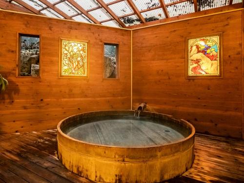 a wooden room with a bath tub in a room at HAKONE GORA ONSEN Hotel Kasansui in Hakone