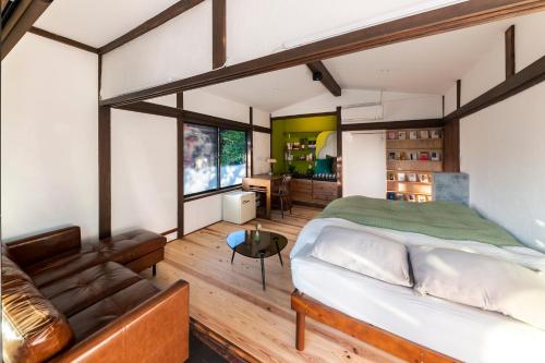 ein Schlafzimmer mit einem Bett und einem Sofa in der Unterkunft 深々 books&stay シンシンブックスアンドステイ in Matsukawa