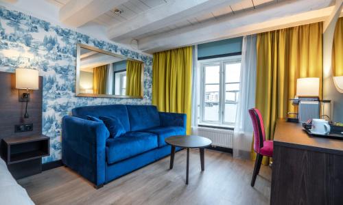 a living room with a blue couch and a table at Thon Hotel Kristiansund in Kristiansund