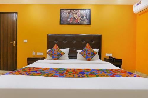 una camera da letto con un grande letto con pareti gialle di FabExpress Taj Home Stay a Nuova Delhi