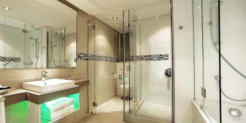 La salle de bains est pourvue d'une douche en verre et d'un lavabo. dans l'établissement Holiday Inn Mauritius Mon Trésor, an IHG Hotel, à Blue Bay
