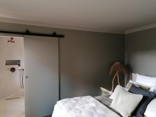 a bedroom with a bed and a sliding door at Hôtel Les Suites Du Maquis in Bonifacio